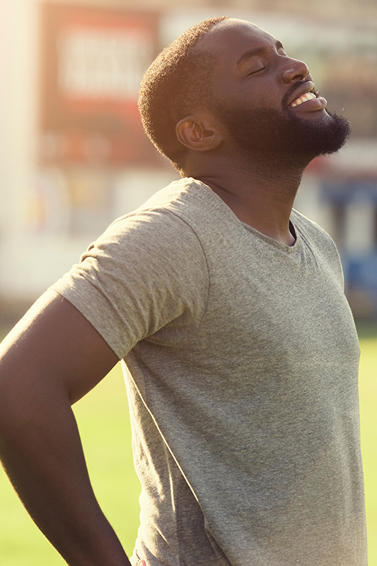 Allergic-Rhinitis-Treatment A black man in a t-shirt smiles and raises his face to the sun due to relief from allergies. Get treatment for allergic rhinitis from Dr. Stephanie King in Salt Lake City.