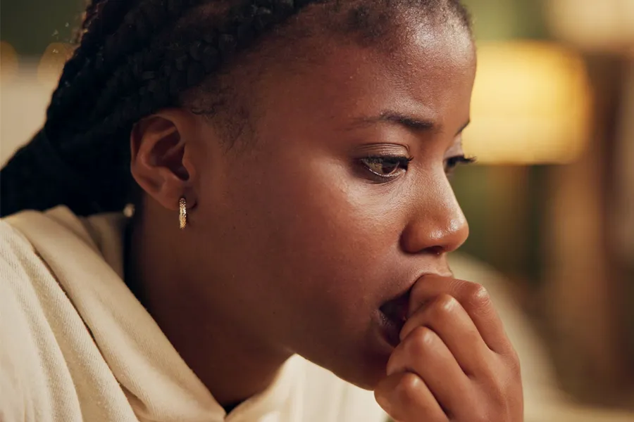 Anxiety-Clinic A black woman bites her nails with worry. Get treatment for anxiety from Dr. Stephanie King in Salt Lake City.