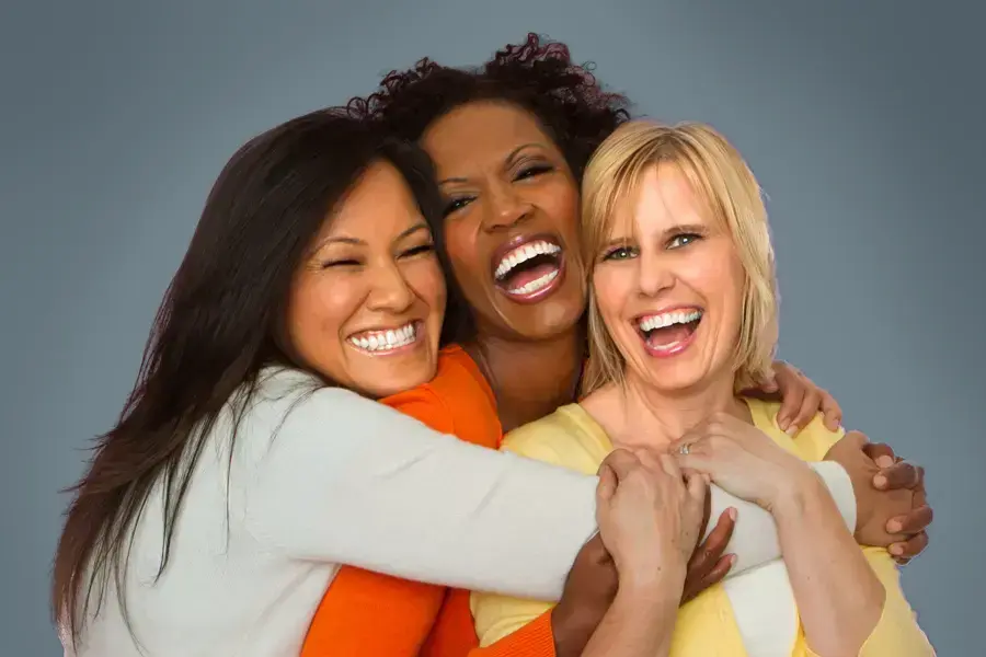 Bioidentical-Hormone-Pellet-Therapy-for-Women-Clinic Three joyful women embracing in a group hug, laughing and smiling after receiving Bioidentical Hormone Pellet Therapy by Dr. Stephanie King in Salt Lake City.