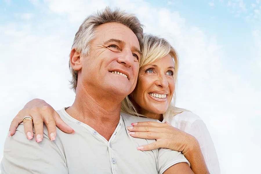 CJC-1295-Peptide-Clinic A mature couple embraces outside under the sky. Get CJC 1295 anti-aging peptides from Dr. Stephanie King in Salt Lake City.