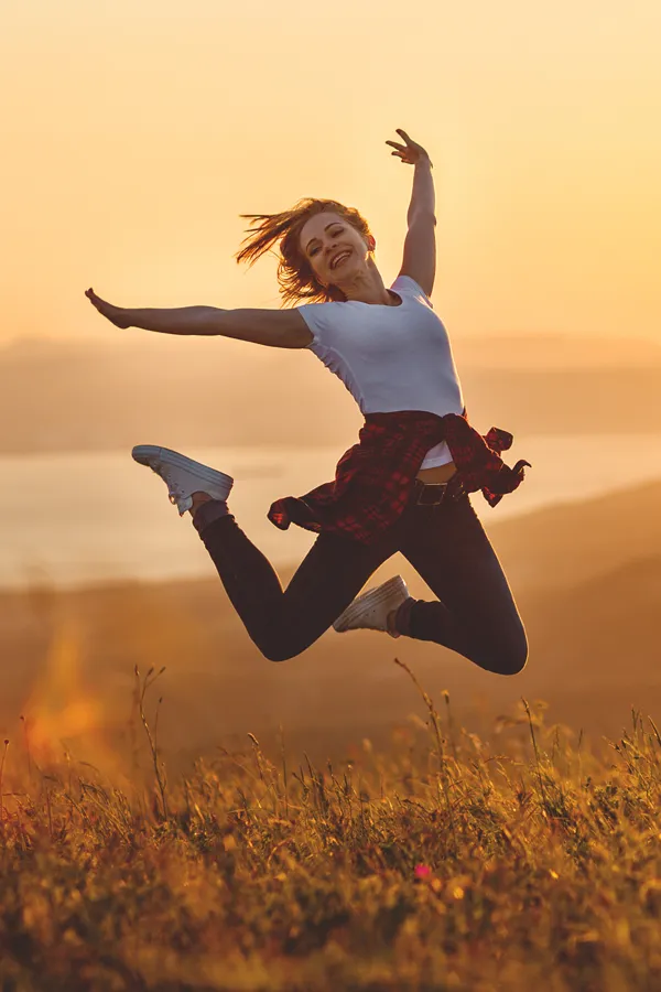 Chronic-Inflammation-Treatment A woman jumps in celebration in a sunset field. Get chronic inflammation treatment from Dr. Stephanie King in Salt Lake City.