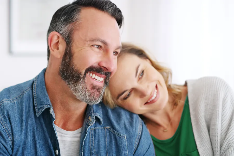 Concierge-Medicine-Clinic A middle-aged white couple in a bright white room smile and lay their heads on each other. Schedule concierge health and wellness services from Dr. Stephanie King in Salt Lake City.