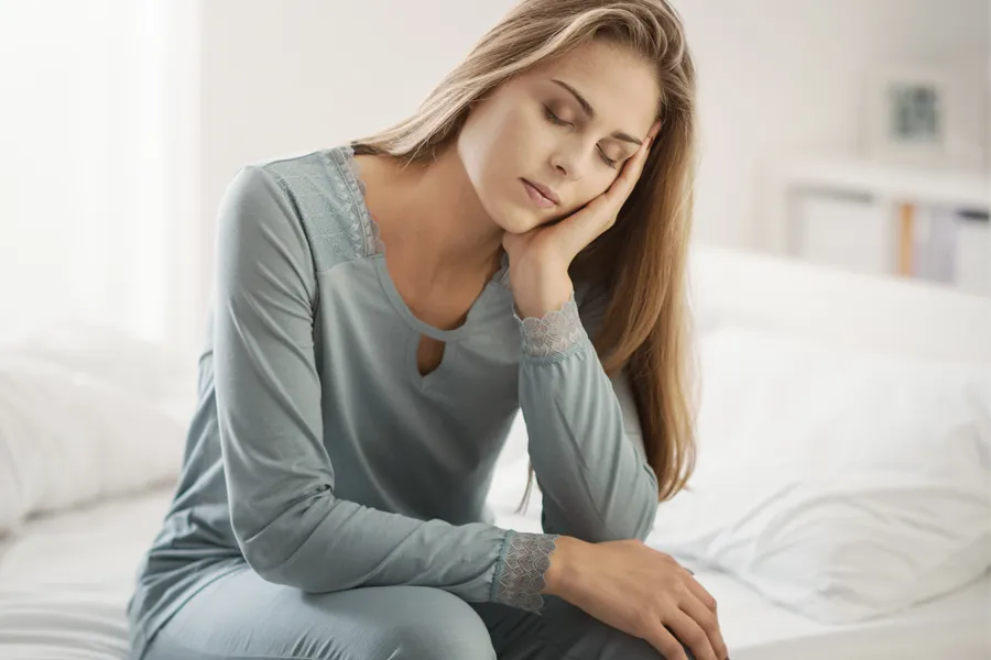 Depression-Clinic A woman sits on the edge of her bed with her head in her hands. Schedule treatment for depression from Dr. Stephanie King in Salt Lake City.