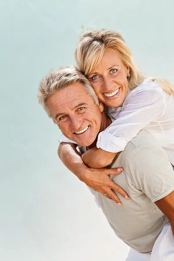 Food-Allergies-Treatment-1 A happy mature couple having fun - the husband is carrying his wife on his back. Get treatment for food allergies from Dr. Stephanie King in Salt Lake City.