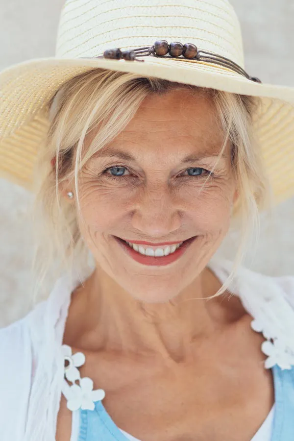 Menopause-Treatment A beautiful, smiling older woman with blonde hair and a sunhat, happy with menopause treatment from Dr. Stephanie King in Salt Lake City.