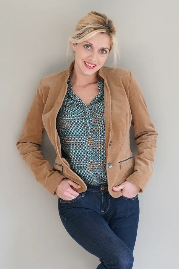Metabolic-Syndrome-Treatment A smiling blonde woman in a tan leather jacket leans against a gray wall. Schedule metabolic syndrome from Dr. Stephanie King in Salt Lake City.
