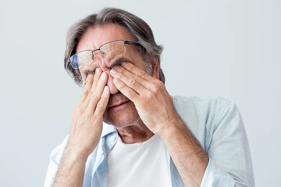 Migraine-Clinic Get migraine relief with Dr. Stephanie King's functional medicine for migraines treatment in Salt Lake City, represented by an older man rubbing his eyes due to head pain.
