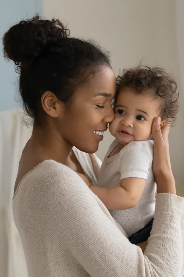 Postpartum-Hormone-Imbalance-Treatment A black woman happily touches her forehead to her infant's head. Get treatment for postpartum hormone imbalance from Dr. Stephanie King in Salt Lake City.
