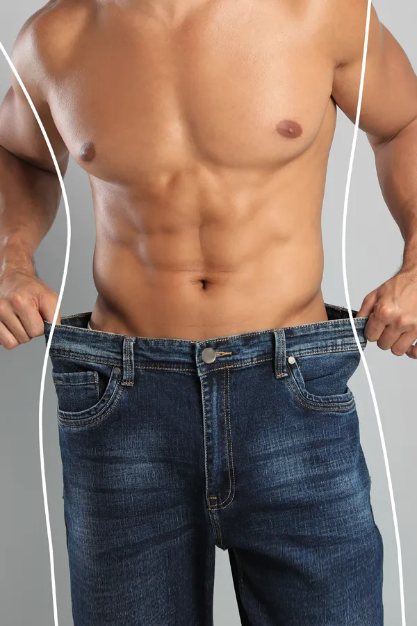 Semaglutide-Weight-Loss-Treatment A strong shirtless man in jeans holds the waistlines of his too-big jeans to show the success of semaglutide weight loss from Dr. Stephanie King in Salt Lake City.