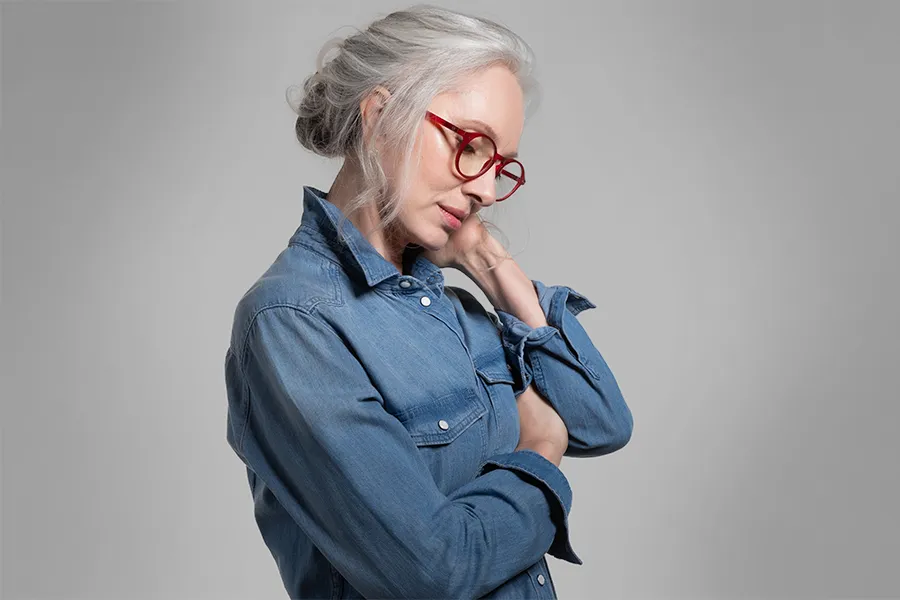 Stress-and-Burnout-Clinic A middle-aged woman rubs her neck from stress. Schedule treatment for stress and burnout from Dr. Stephanie King in Salt Lake City.