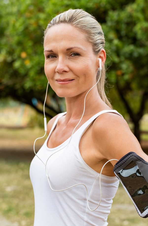 fibromyalgia-doctor Middle-aged, active woman taking a break to smile at the camera during a run, representing successful Bioidentical Hormones for Fibromyalgia Relief offered by Dr. Stephanie King in Salt Lake City.